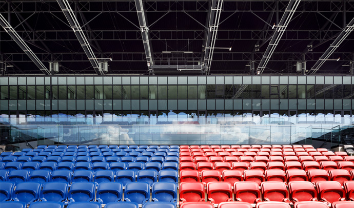 Niebieskie i czerwone krzesła na trybunach Stadionu Pogoni w Szczecinie